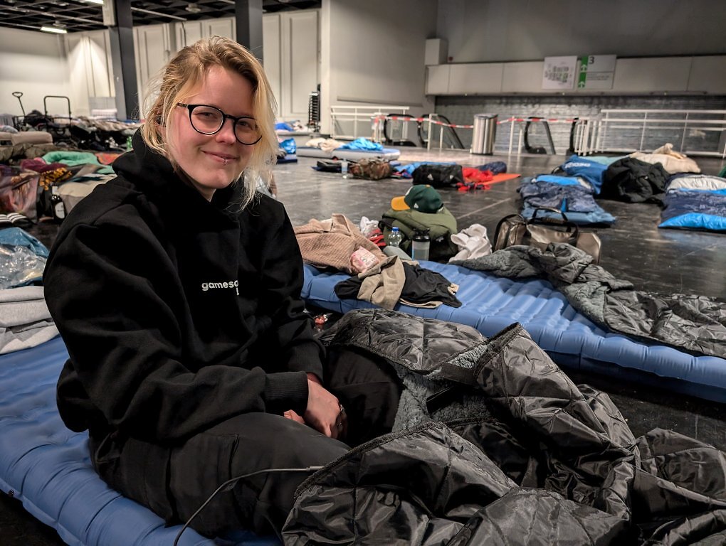 Frau auf einer Isomatte in einer Messe-Halle