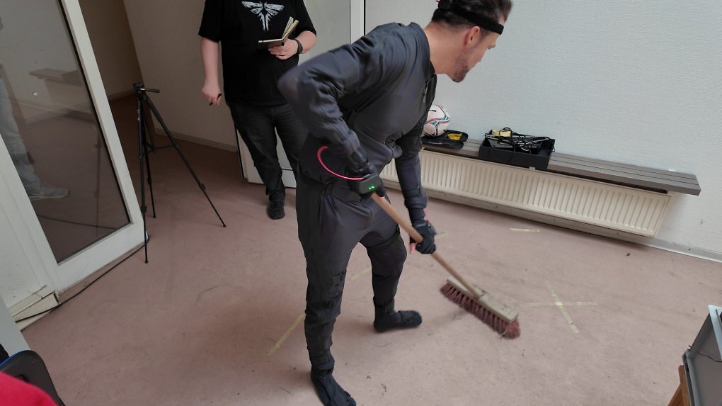 Animationschef Guido Neumann führt uns den Motion-Capture-Anzug vor und demonstriert, wie die Bewegung eines fegenden Menschen aufgezeichnet wird.