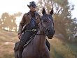 Arthur Morgan aus Red Dead Redemption 2 beim Ausritt auf einem Pferd.