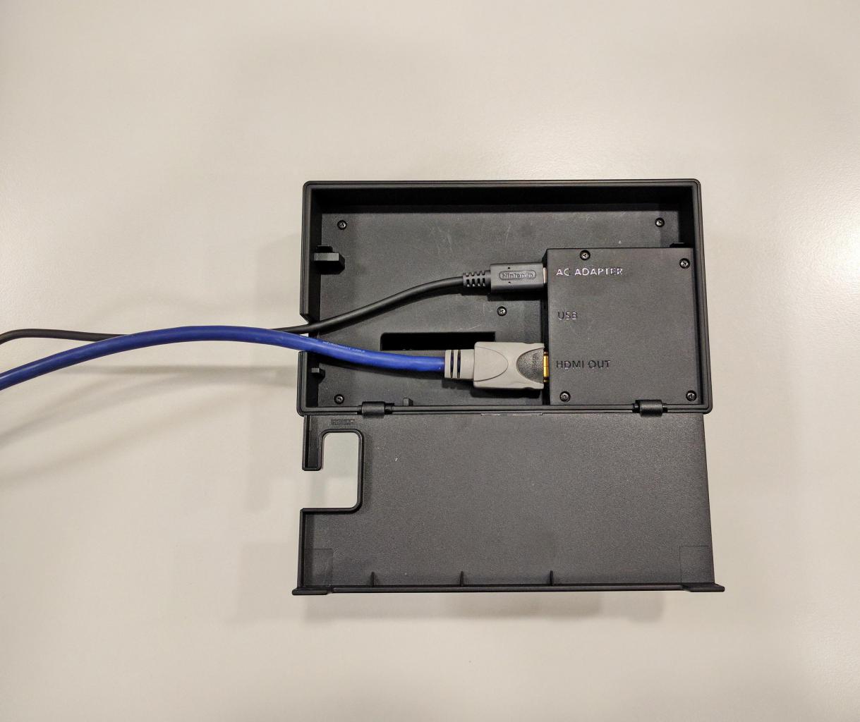 [03/03/2017] Das Strom- und HDMI-Kabel (liegen beide der Packung bei) schließt ihr hinten an der Switch-Station an. Dank der Klappe werden die Kabel geschickt versteckt.
