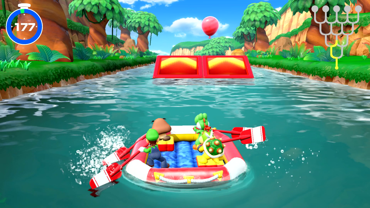 Gumba, Yoshi, Luigi und Bowser Jr. fahren im Modus Raft-Abenteuer von Super Mario Party für Nintendo Switch über den Fluss auf eine Sprungschanze und einen Minispiel-Luftballon zu.