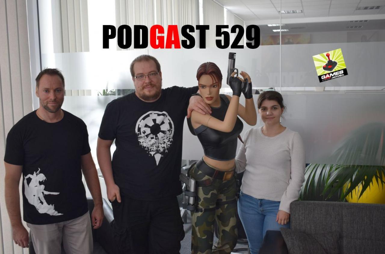Das Podcast-Trio Andy, Matthias und Ebru steht neben einer Figur von Lara Croft. 