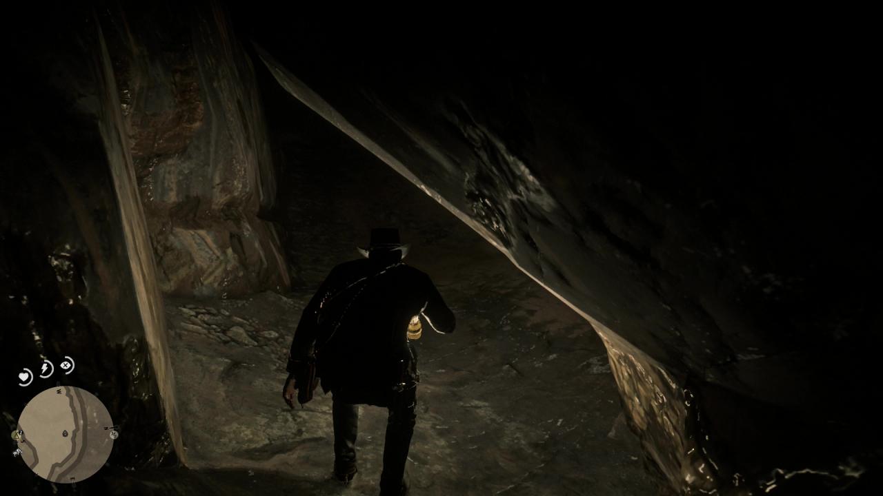 Arthur zwängt sich in RDR2 hindurch durch die Höhle.