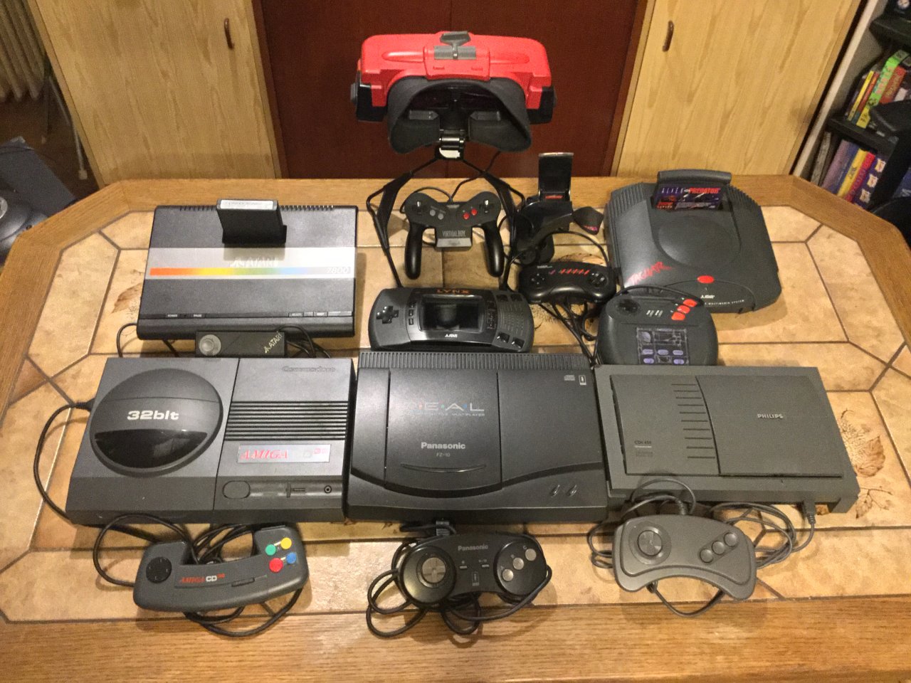 [23/12/2020] Ein Gruppenbild gescheiterter Konsolen: In der oberen Reihe seht ihr den Atari 7800, den Virtual Boy, die R-Zone und den Atari Jaguar. In der unteren Reihe sind der Amiga CD32, das 3DO von Panasonic und Philips CD-i vereint. In der Mitte liegt zudem gut versteckt ein Atari Lynx. (1)