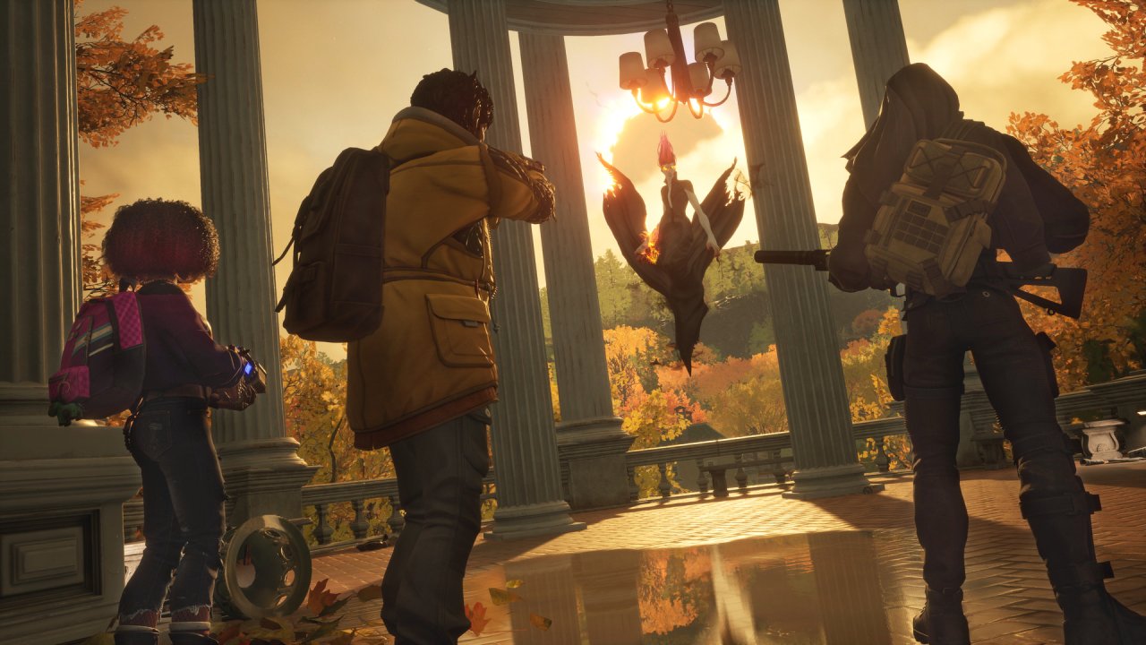 Drei Spieler stehen vor einem Sonnenuntergang in Redfall.