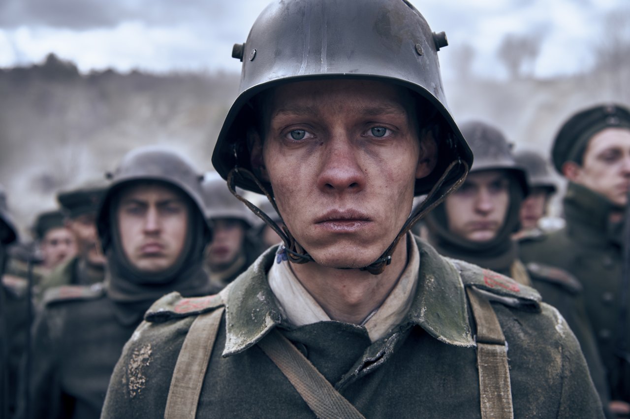 Ein Bild von Hauptfigur Paul (Felix Kammerer), der in Uniform emotionslos in der Menge steht.