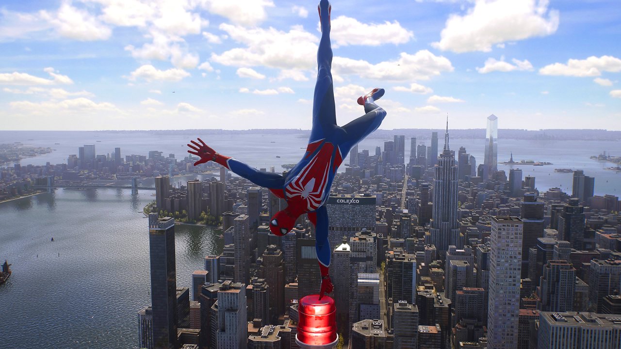 Spider-Man balanciert auf einem Finger auf der Spitze eines Wolkenkratzers mit New Yorks Skyline im Hintergrund.