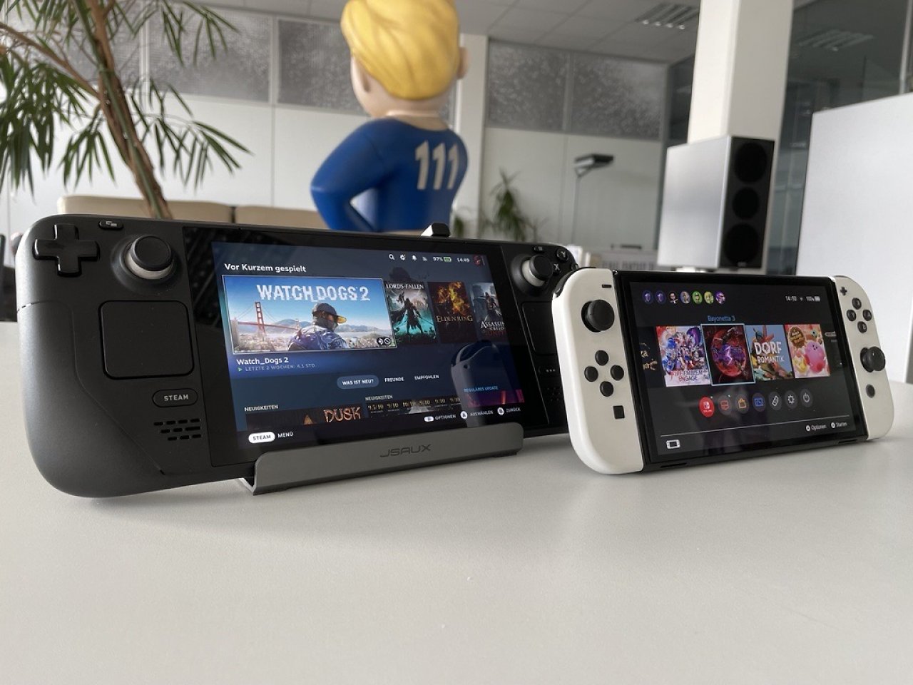 Ein Steam Deck und eine Nintendo Switch OLED stehen nebeneinander. Beide zeigen ihren Home-Bildschirm an.