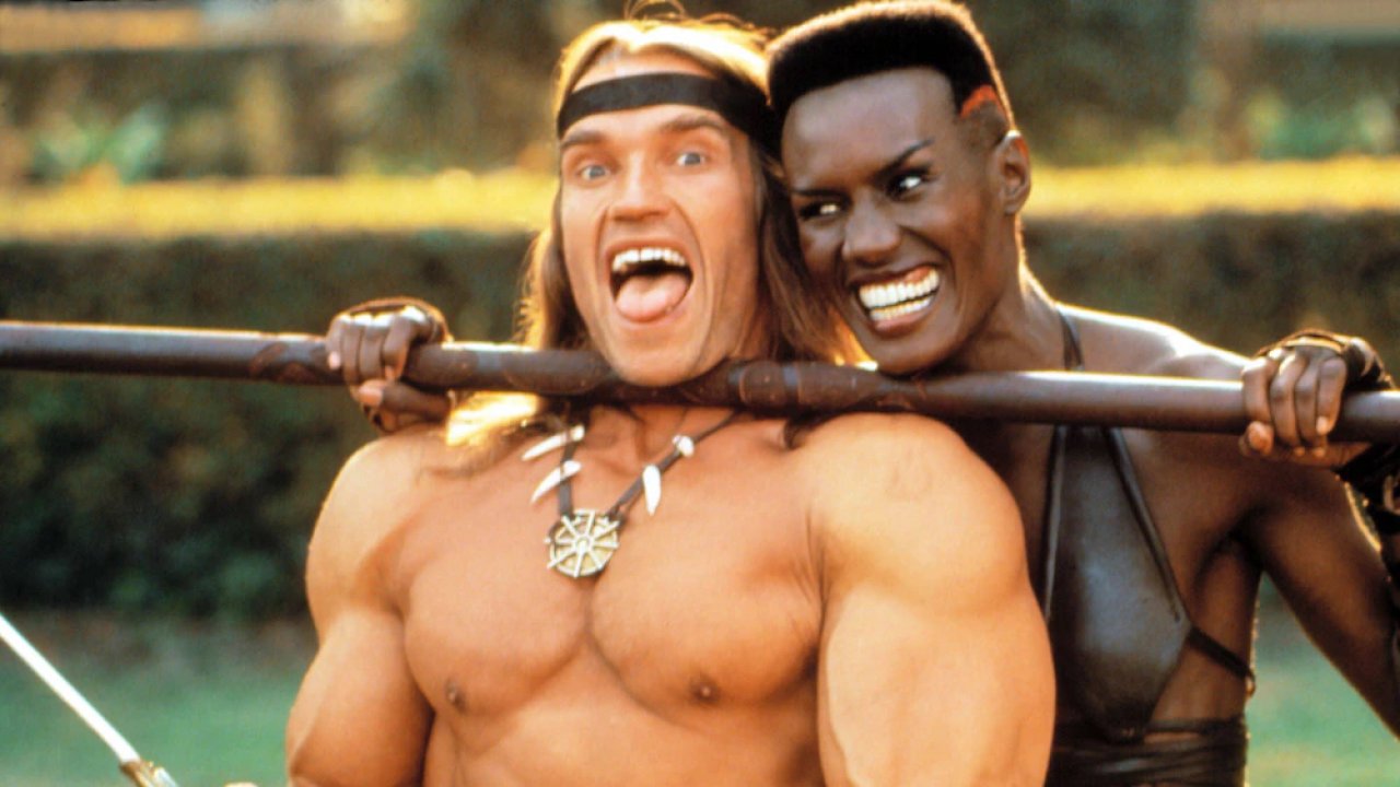 Arnold Schwarzenegger und Grace Jones albern am Set von Conan 2 herum.