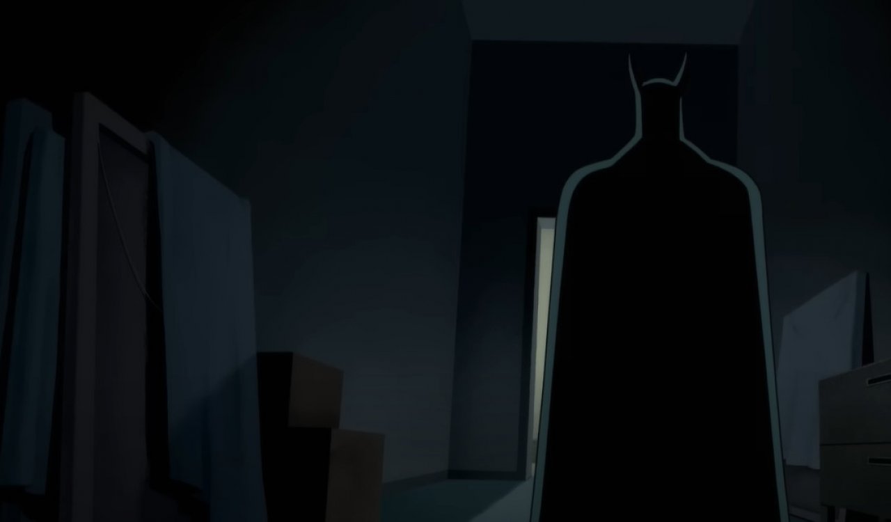 Batman von hinten steht vor einem beleuchteten Zimmer