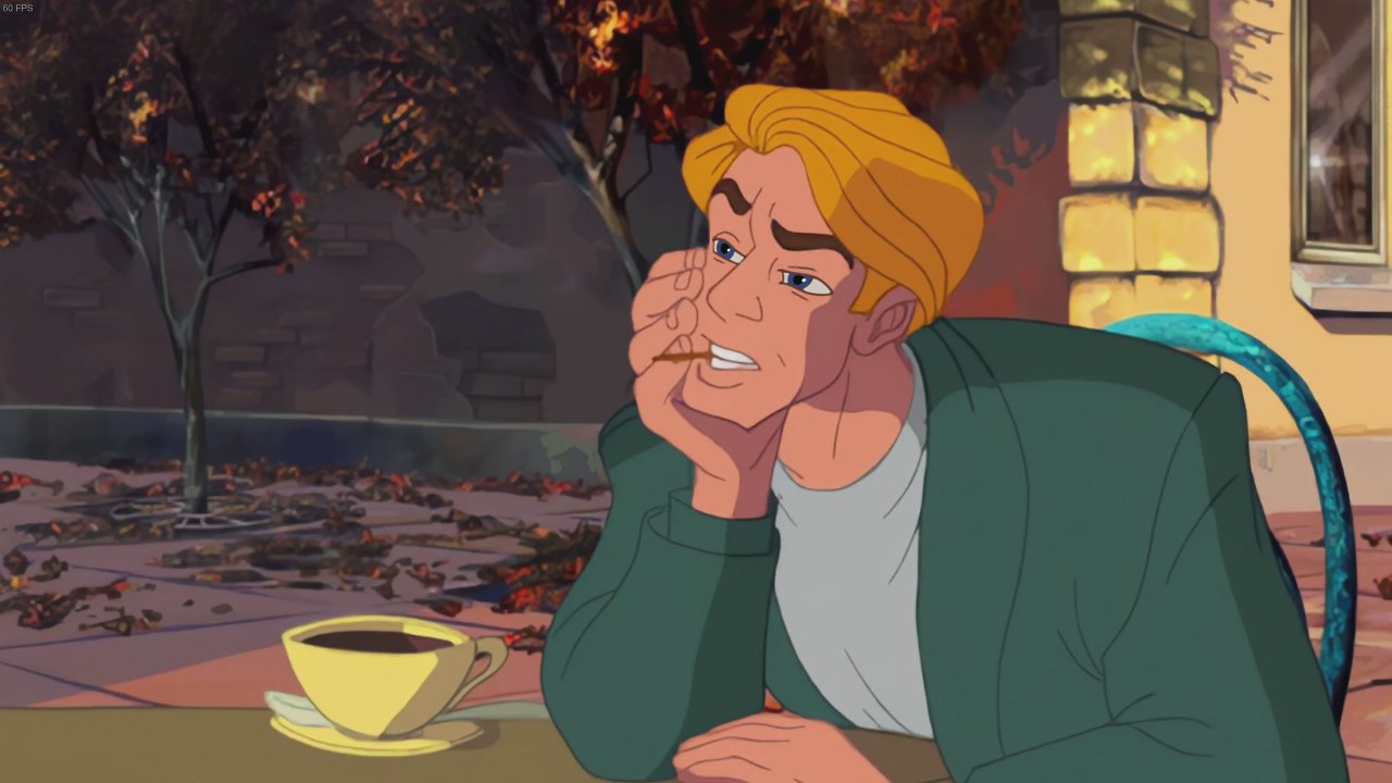 George Stobbard sitzt mit einer Tasse Kaffee vor einem Café
