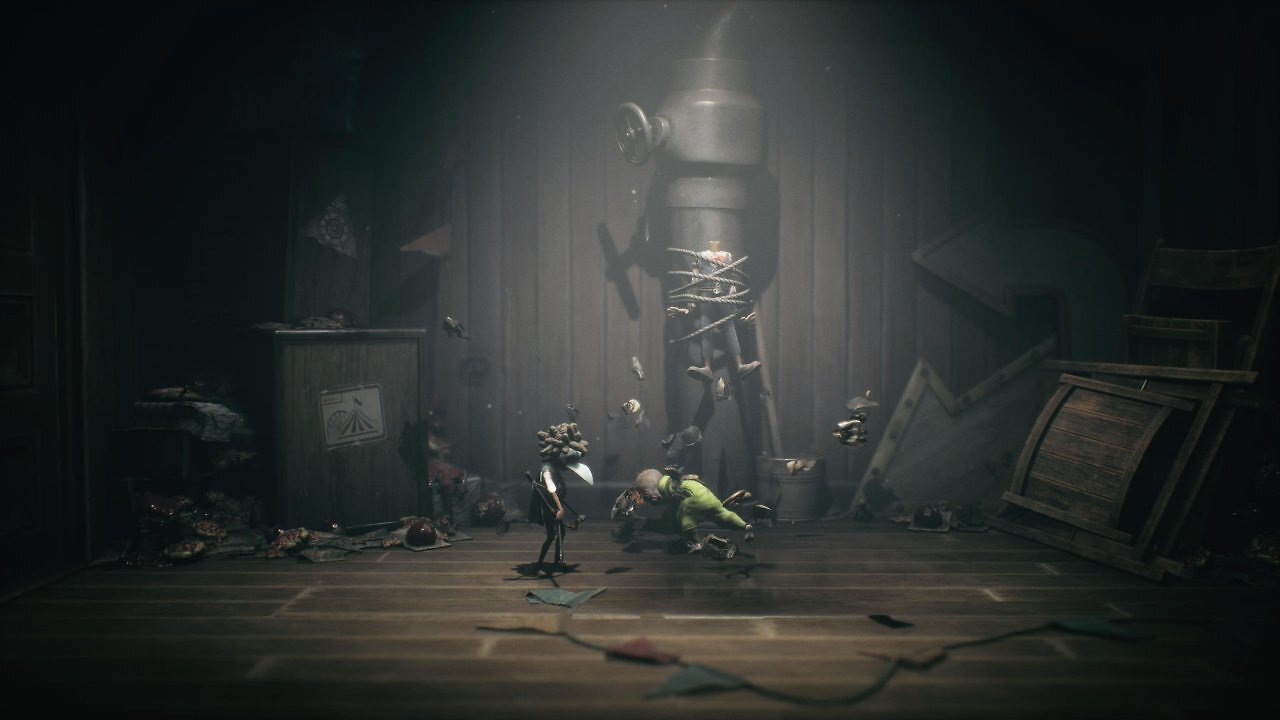 Alone zertrümmert den Kopf einer Puppe. Low steht daneben und beobachtet sie.