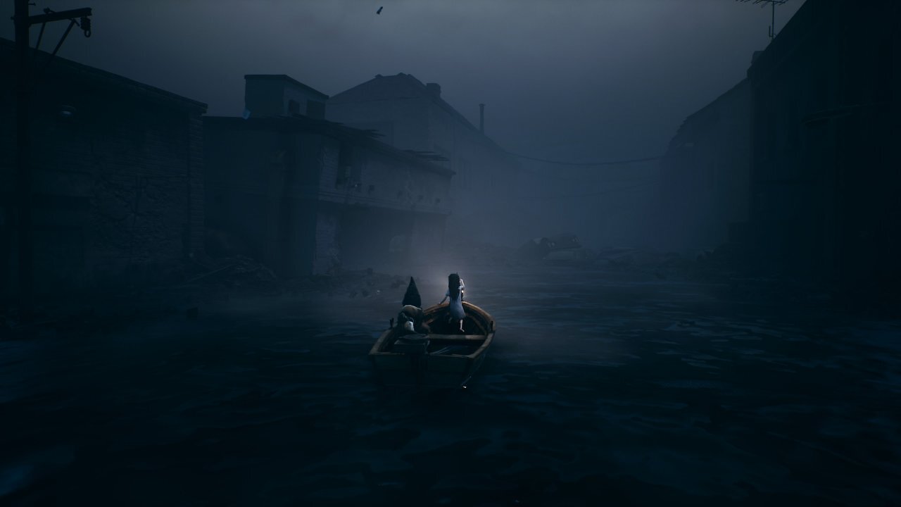 Zwei Kinder fahren in einem Boot durch eine überflutete Stadt.