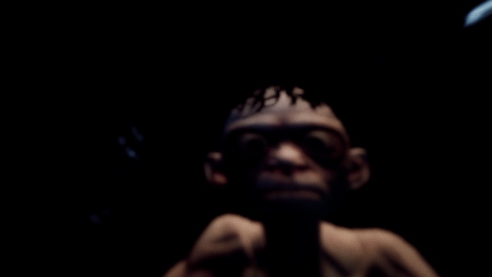 Ein unscharfer Gollum blickt in eine spiegelnde Wasserpfütze.
