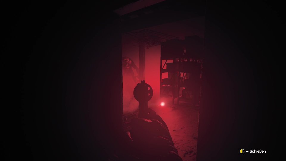 EIn Blick durch ein Visier in einem in rotes Licht getränkten Raum
