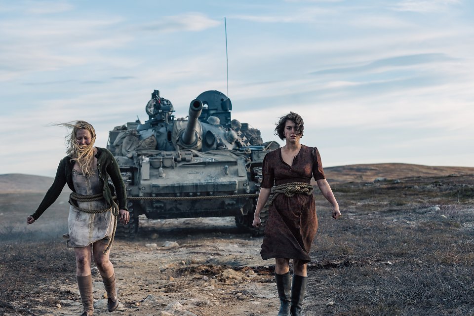 Zwei von den Nazis gefangene Frauen, die wie Pferde an einen Panzer gebunden wurden, um die Nazis vor Tretminen zu schützen.