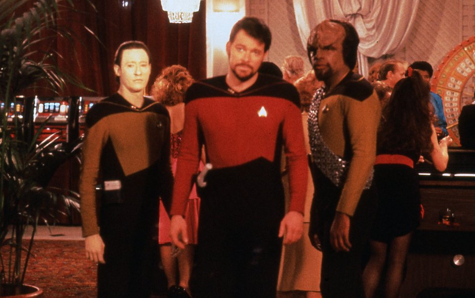 Data, Worf und der nunmehr bärtige Riker sind gefangen im surrealen "Hotel Royale".
