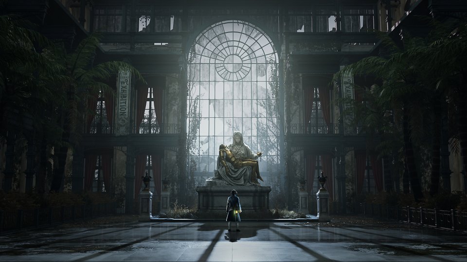 Eine Figur steht vor einer großen Statue in einer Halle.